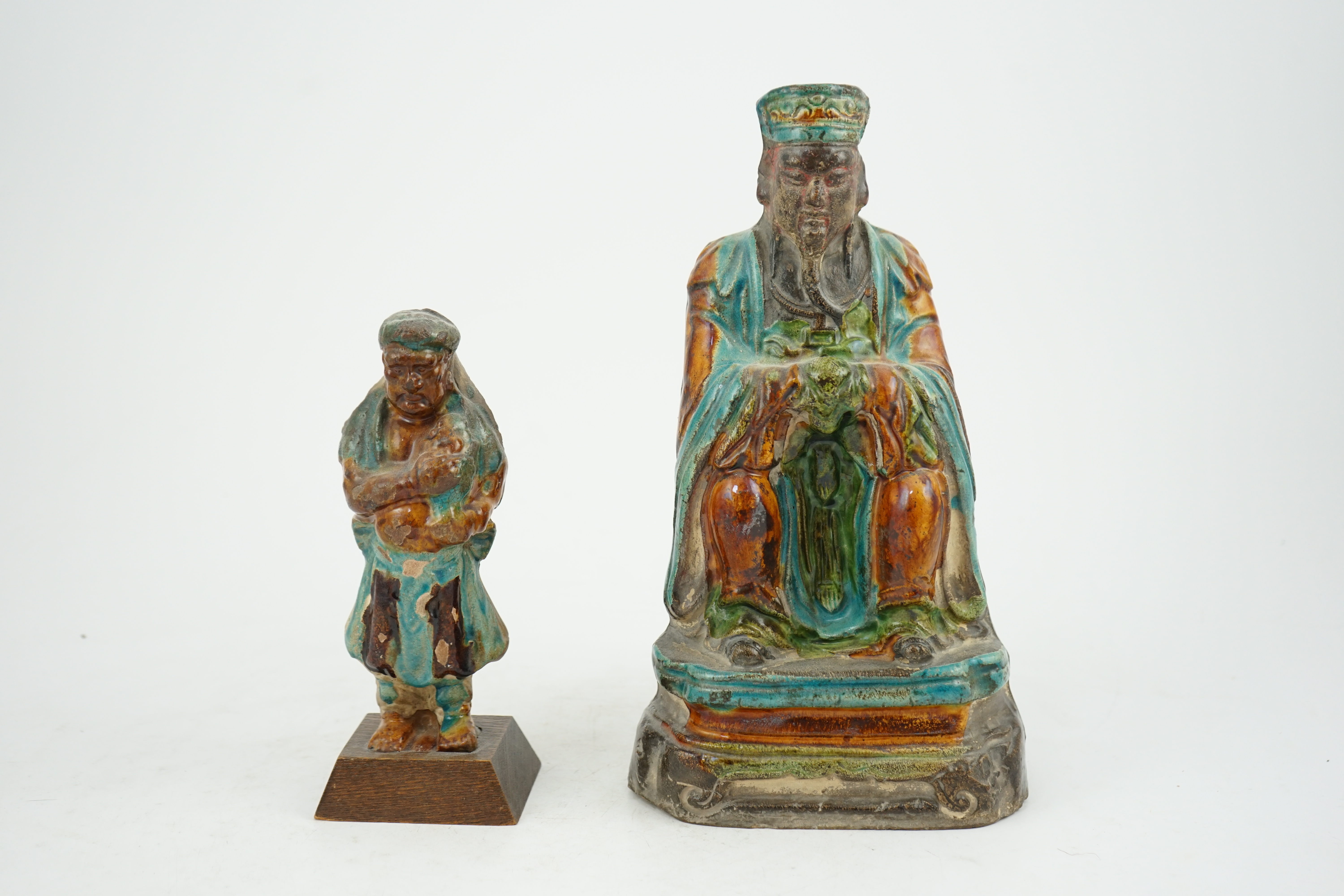 Two Chinese sancai glazed figures of a seated dignitary and a standing attendant, Ming dynasty